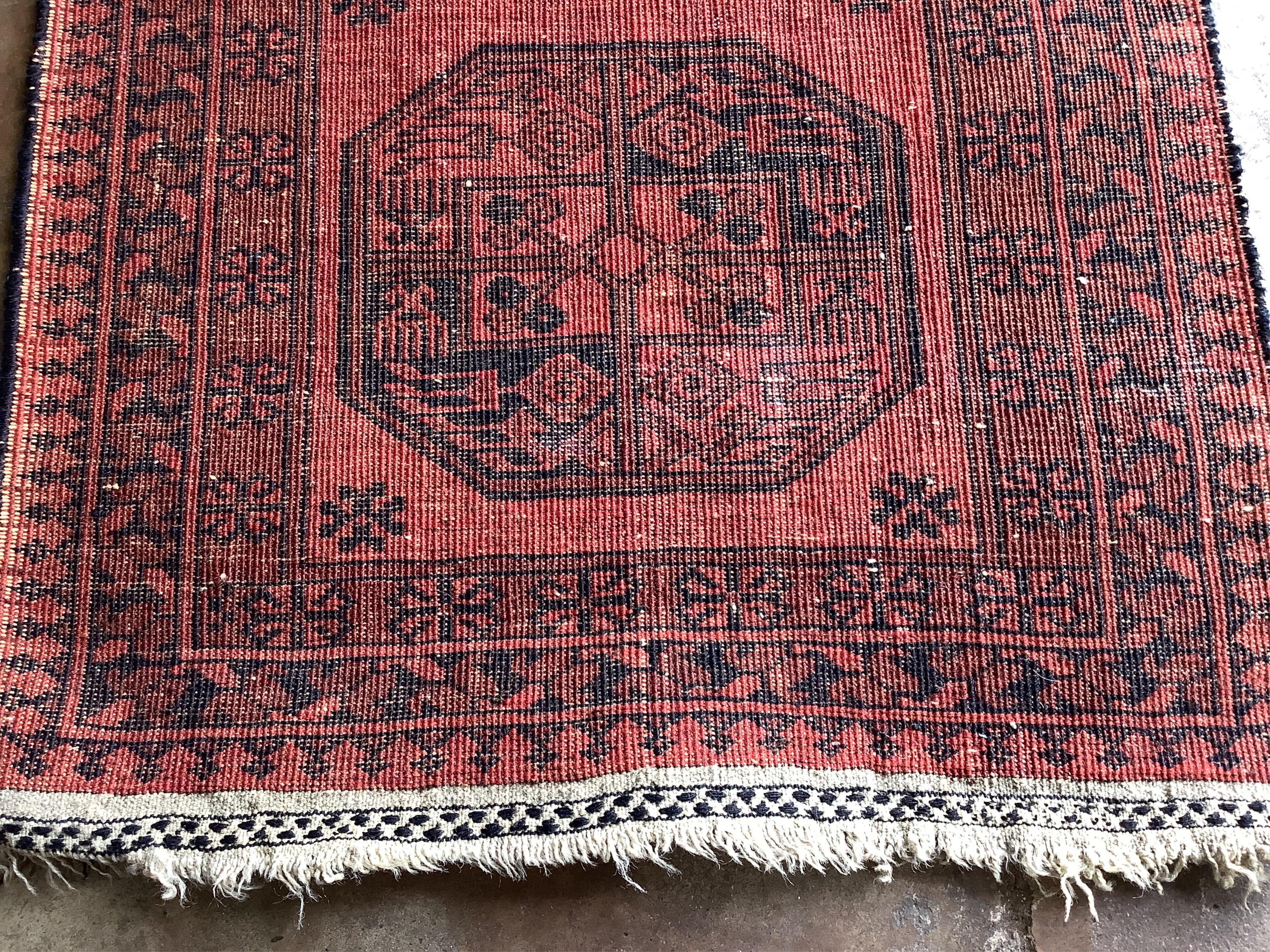 A pair of Afghan red ground rugs, each 144 x 75cm. Condition - fair